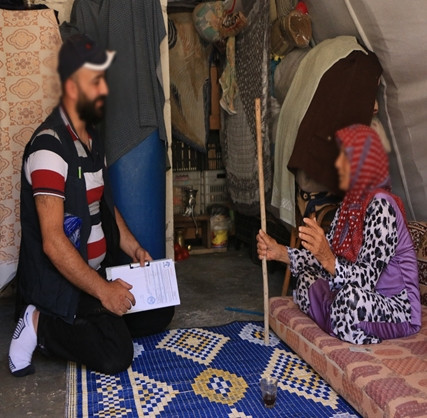 An aged woman lives alone in her tent in need of help.