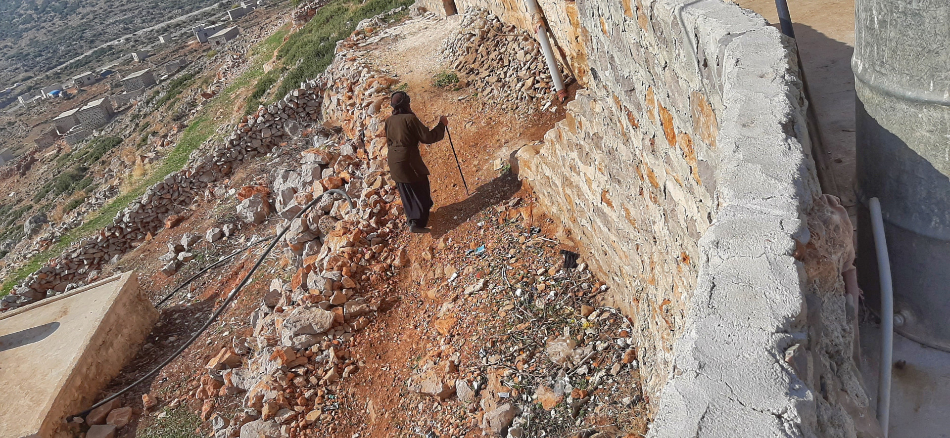 An elderly woman works in olive harvest and live in the mountain