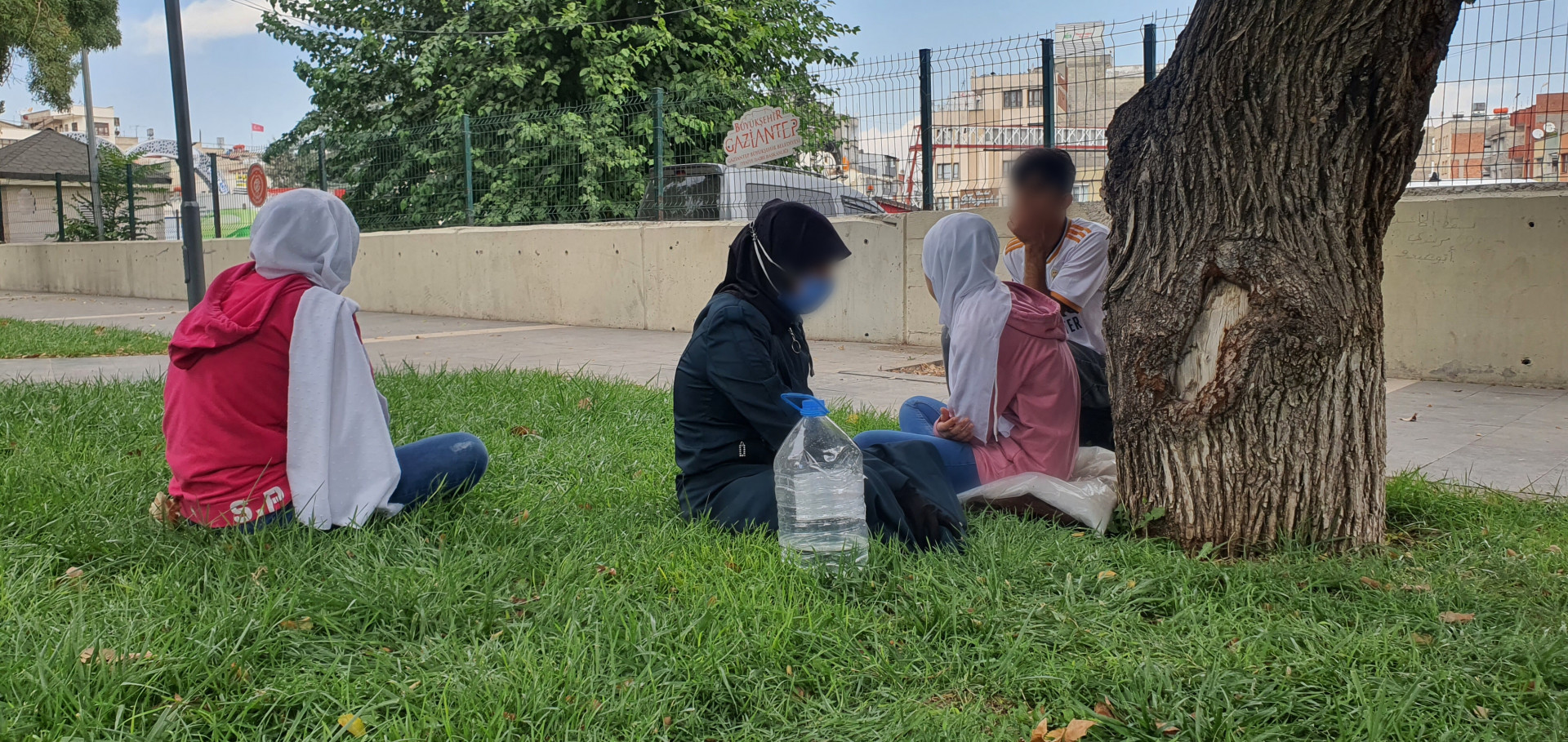A widowed woman and orphaned children have no shelter except the shade of trees.
