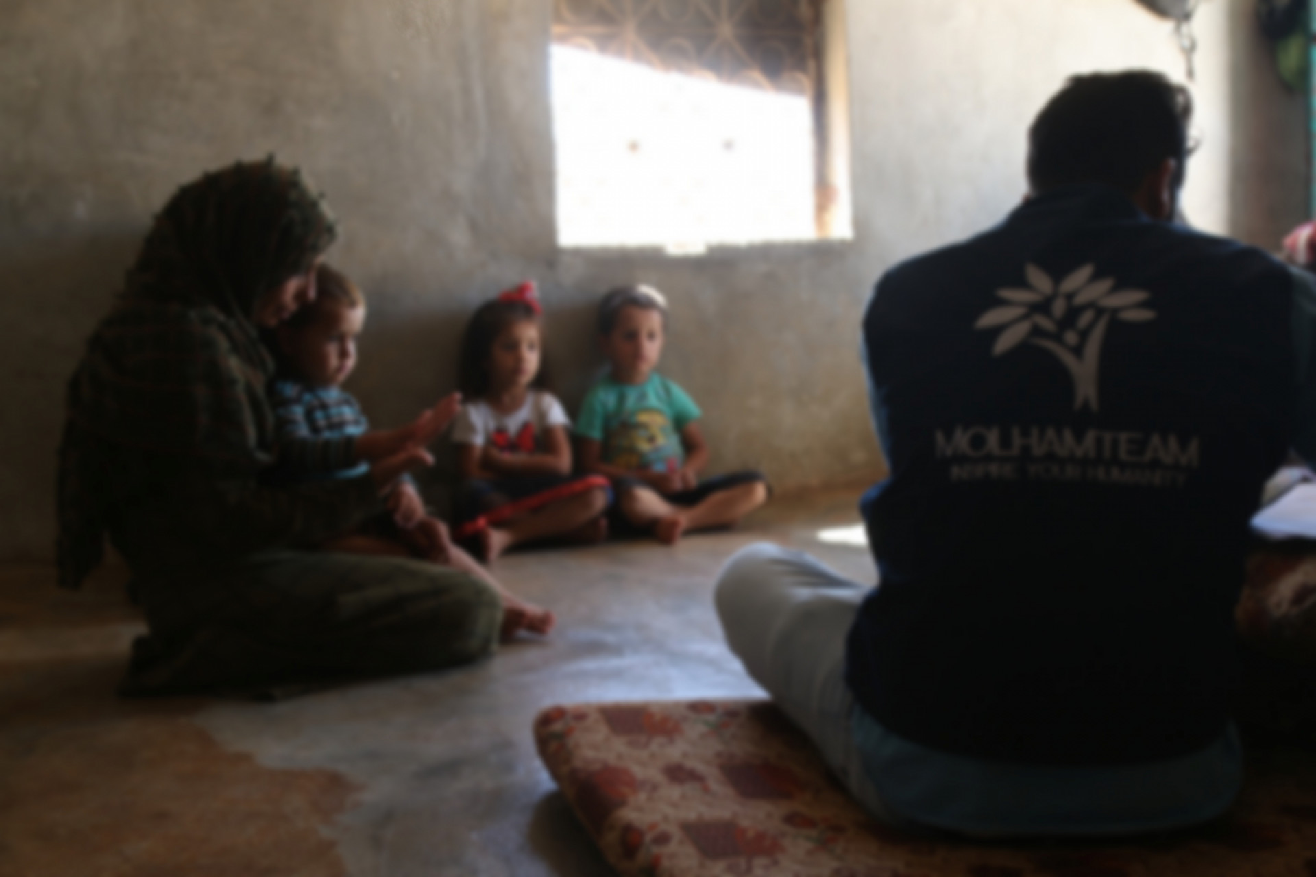 Eine Mutter und ihre Kinder leben unter schlechten humanitären Bedingungen ohne Ernährer
