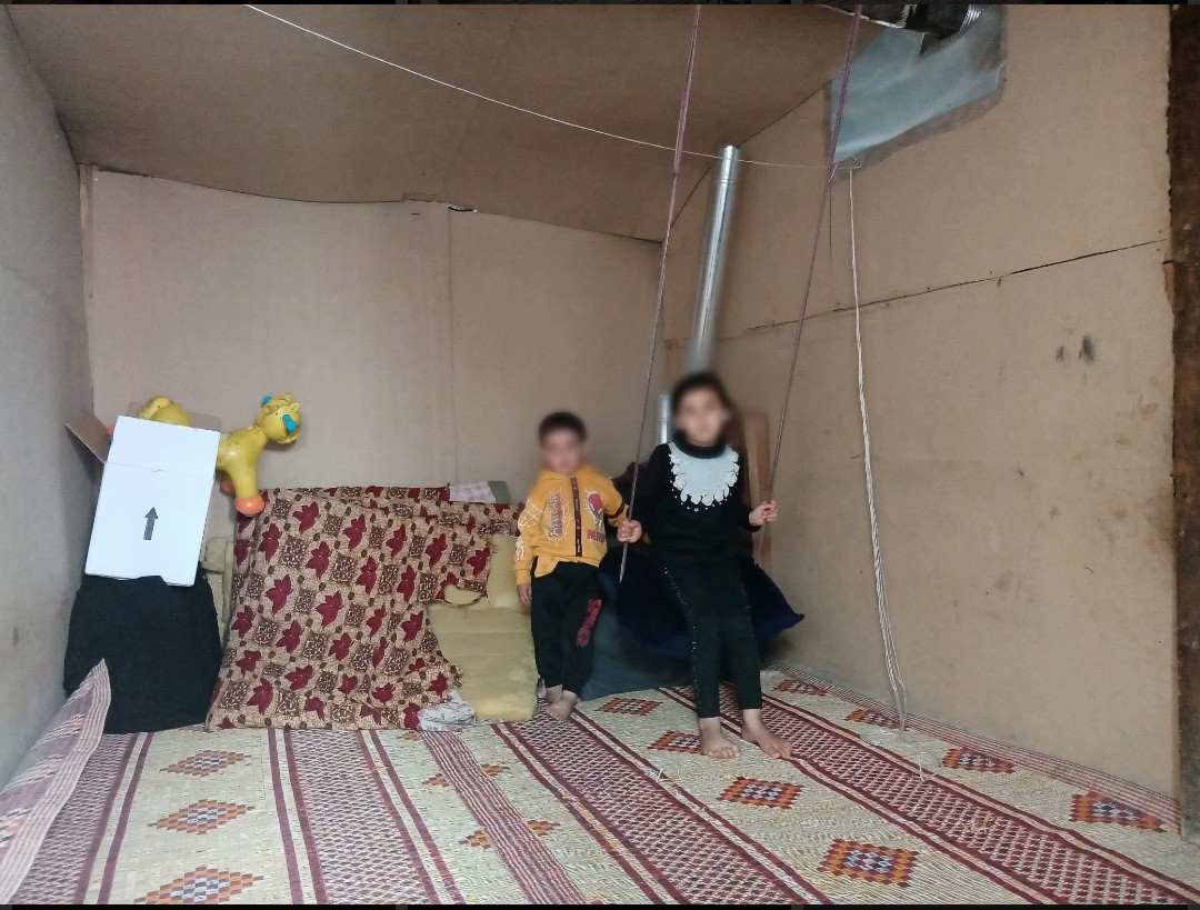 A woman lives with her children in a tent many years ago
