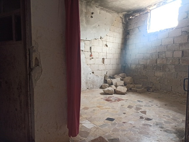 A family lives in a destroyed house