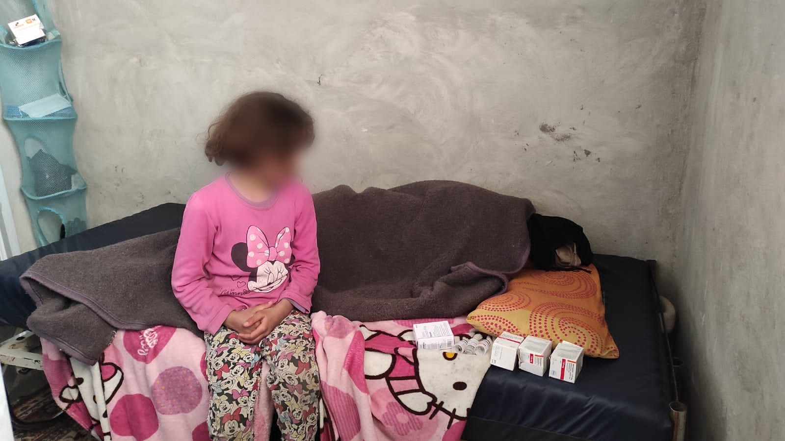 تجلس الطفلة وتنظر لوالدتها التي انهك جسدها مرض السرطان ولاتملك ثمن العلاج